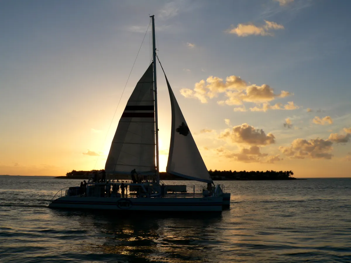 Sailing catamaran full of passengers heading out at sunset off Key West